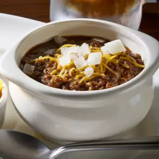 This Texas tradition, made from Goodstock by Nolan Ryan ® Ribeye steak makes this well seasoned homemade chili special. Served with shredded Cheddar cheese, fresh chopped onions and crackers.
