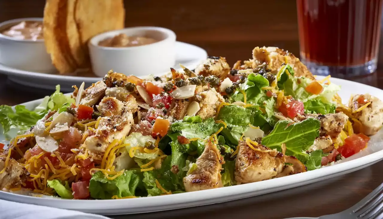 Grilled, marinated chicken tenders are diced and served on Romaine and green-leaf lettuce, tomatoes, capers, Cheddar cheese, Parmesan cheese and toasted almonds.