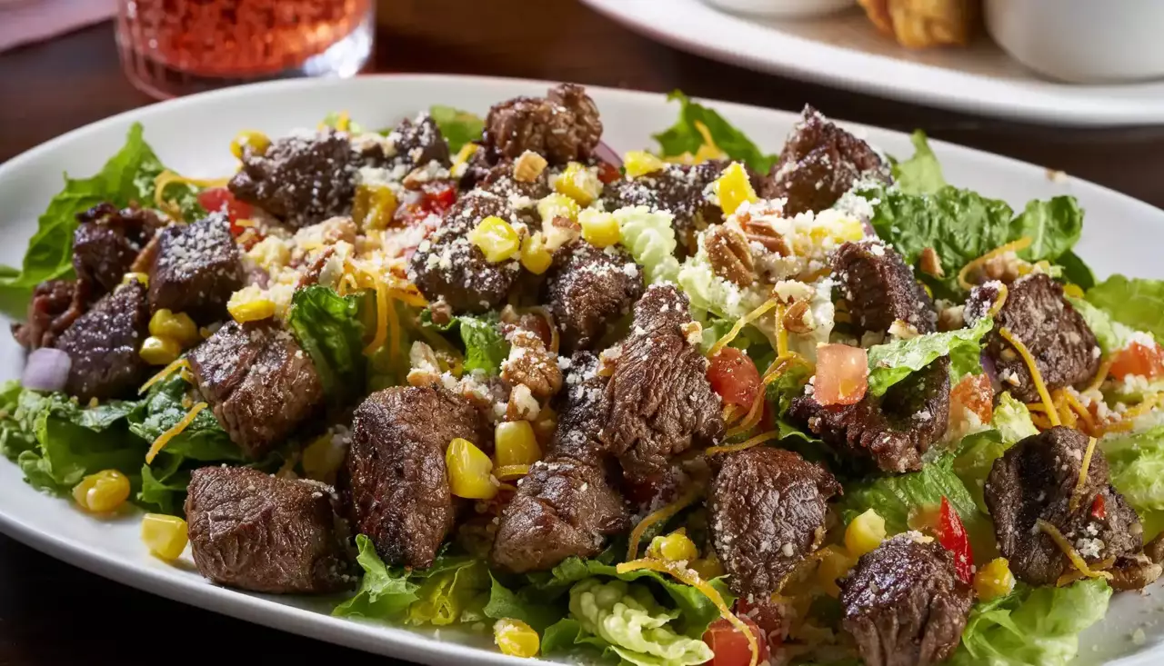 Lightly seasoned Filet Mignon grilled and served over a bed of Romaine and green-leaf lettuce, grilled corn relish, tomatoes, Cheddar cheese, Parmesan cheese and chopped pecans.