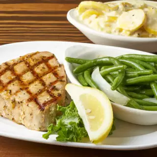 Charbroiled Tuna steak, lightly marinated and cooked to a temperature of medium to medium well. Served with a lemon-butter sauce for dipping and two sides of your choosing.
