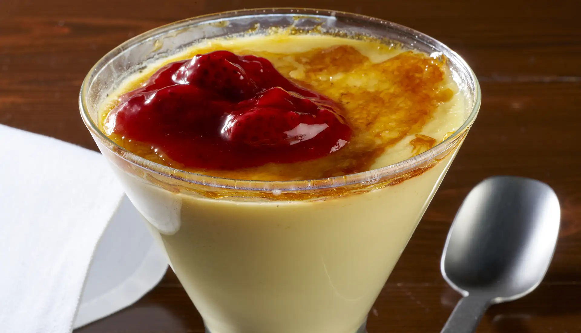 Our version of Crème Brûlée begins with white chocolate custard, we then add a healthy dab of strawberry topping on its caramelized sugar top.