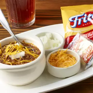 This Texas tradition, made from Goodstock by Nolan Ryan ® Ribeye steak makes this well seasoned homemade chili special. Served with shredded Cheddar cheese, fresh chopped onions, Fritos and crackers.